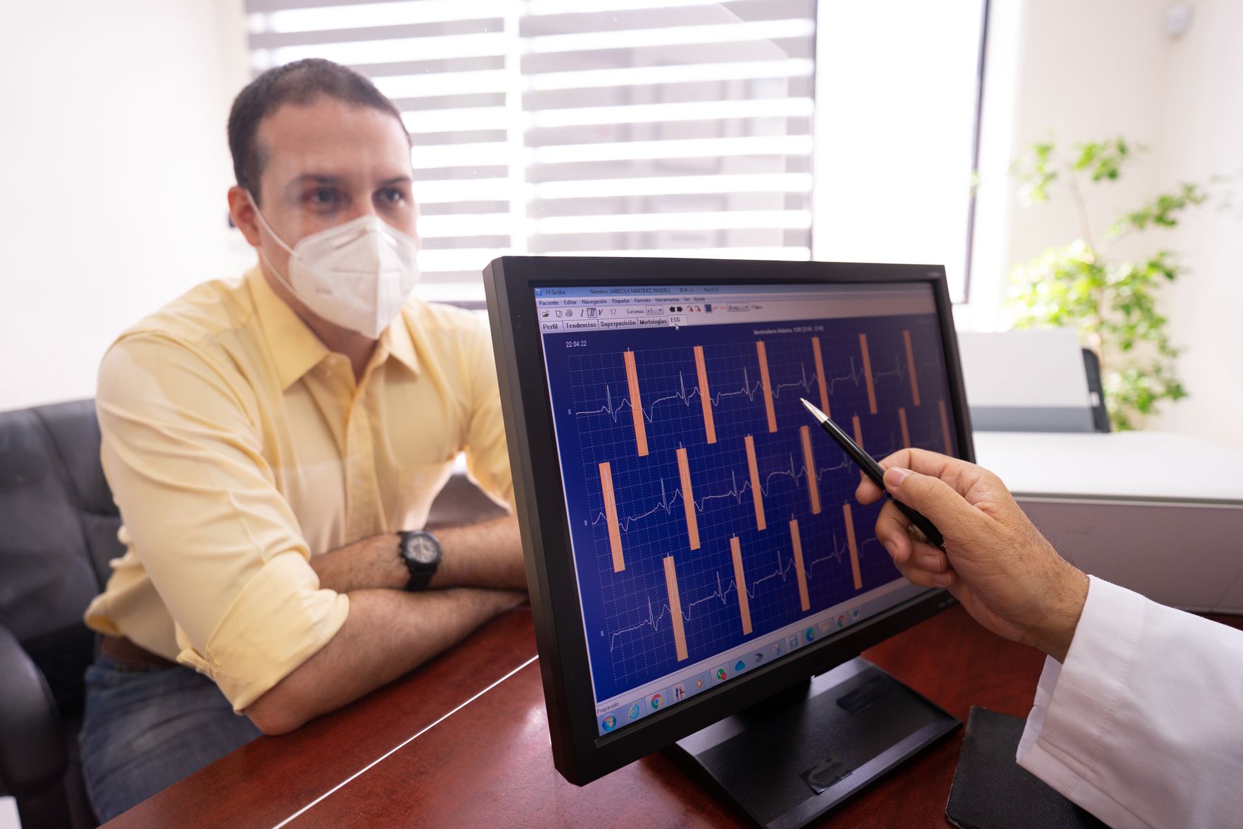 A clinician reviewing an electrocardiogram tracing with a patient