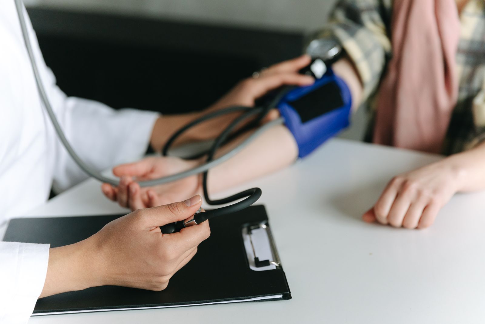 A clinician measuring a patient's blood pressure with a cuff